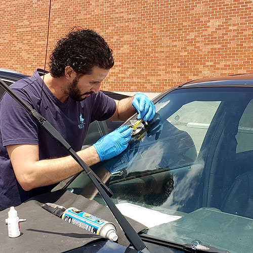 mobile windshield technician repairing the crack for customer car in the parking lot by Speers Auto Glass